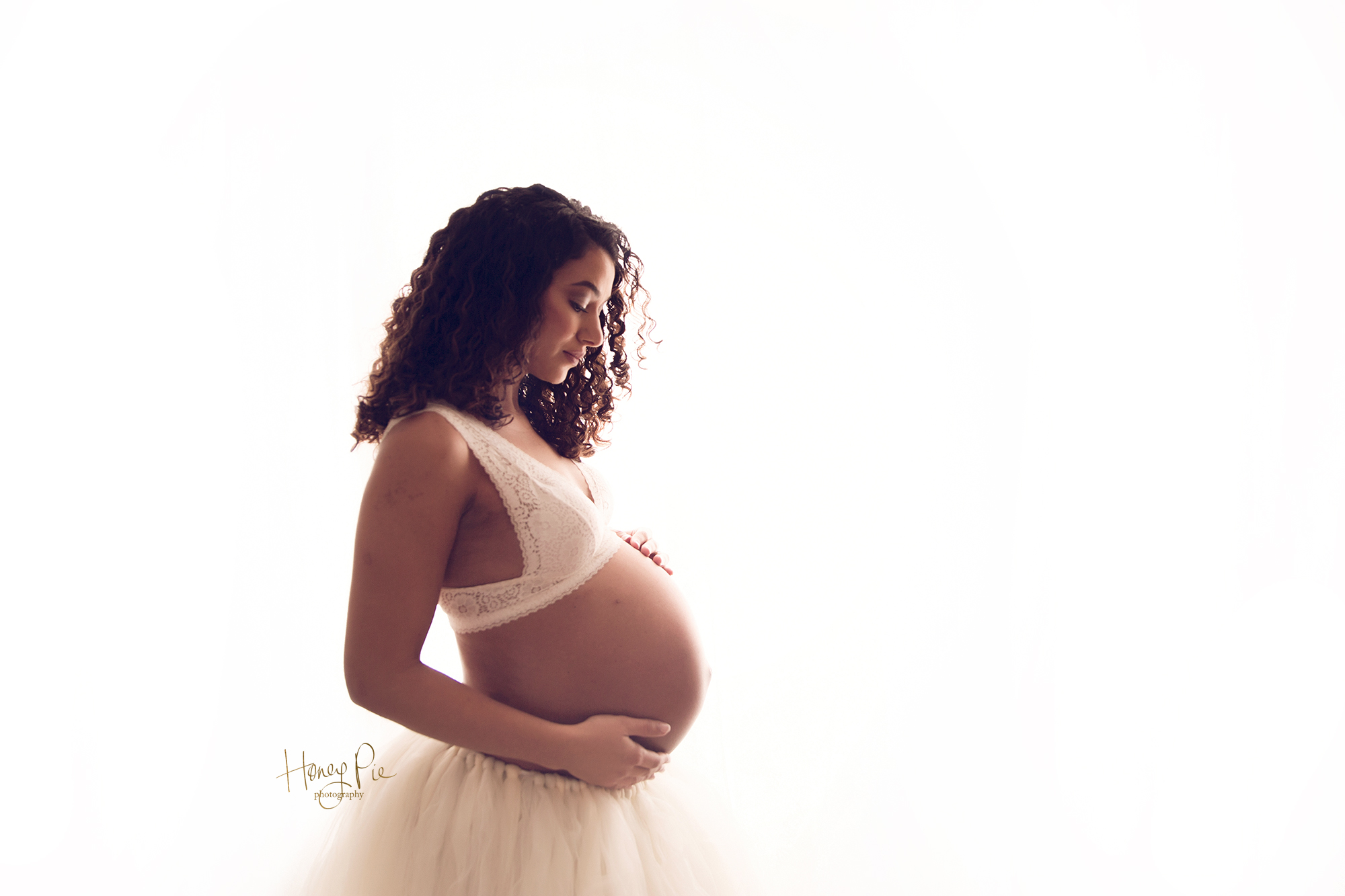Mama to be gazing at her beautiful baby bump during maternity photoshoot sussex