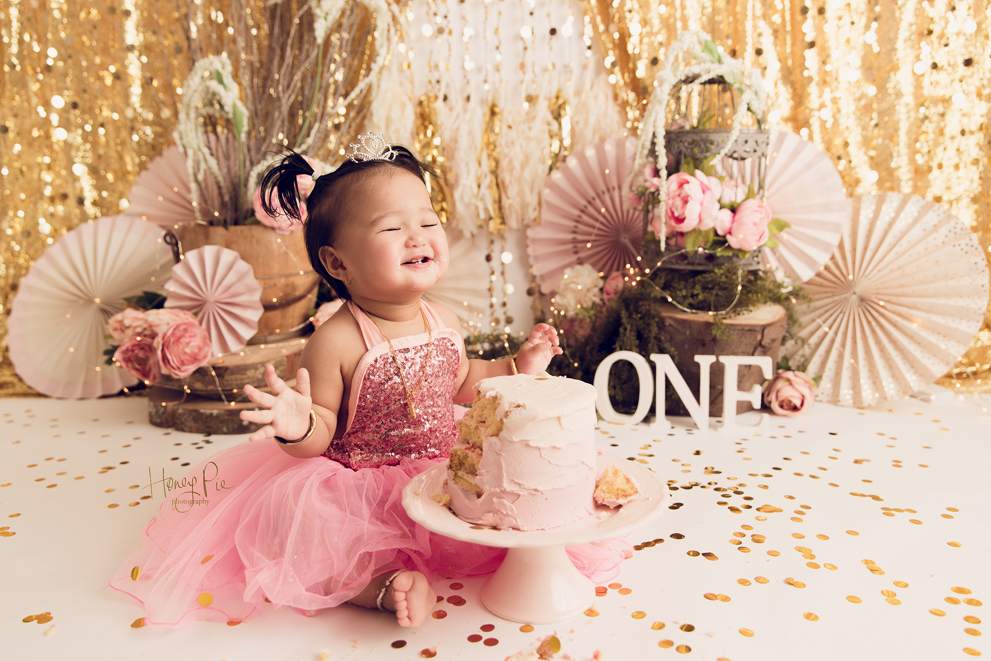 Baby smiling with cake covered hands at a Cake Smash photoshoot worthing