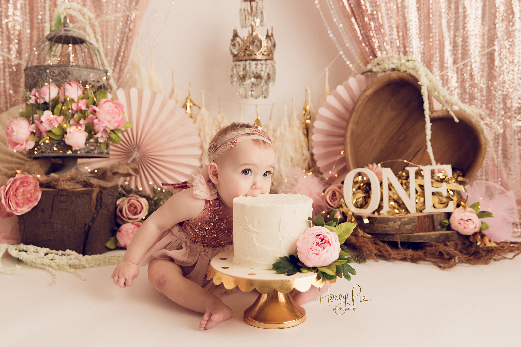 Baby face diving into cake at first birthday photoshoot