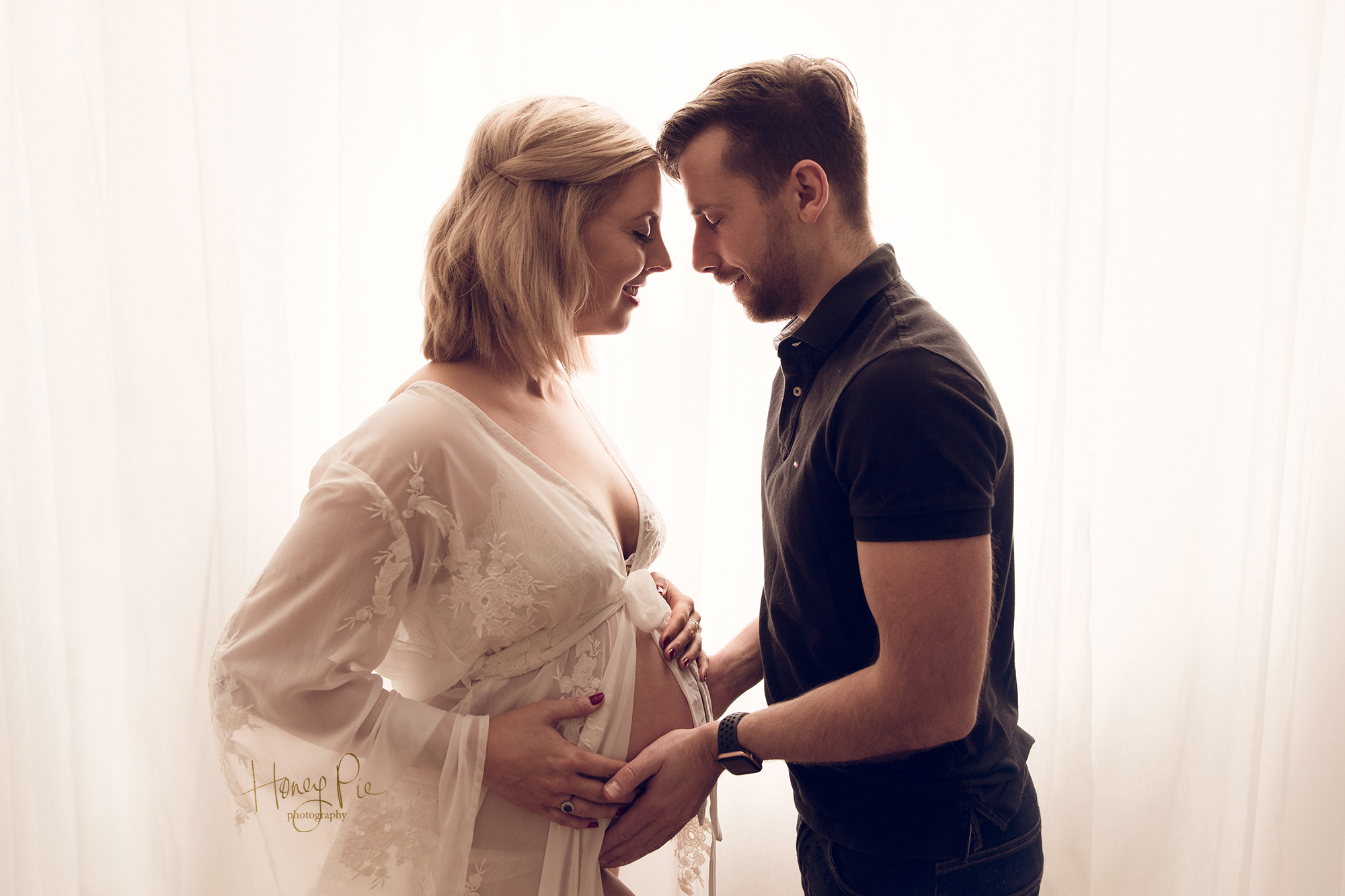 Parents to be cradling baby bump during sussex photoshoot