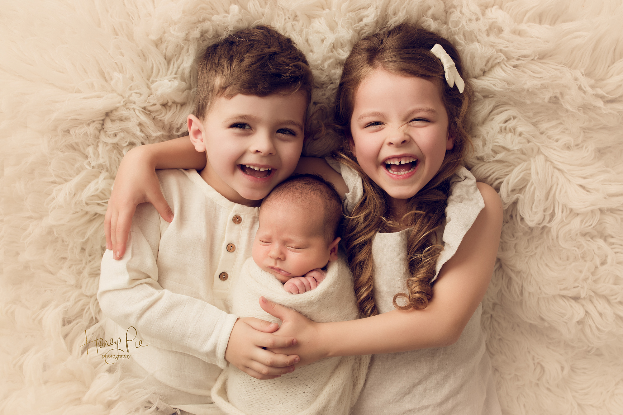 Big brother & sister siblings loving their newborn baby brother at a photoshoot in worthing