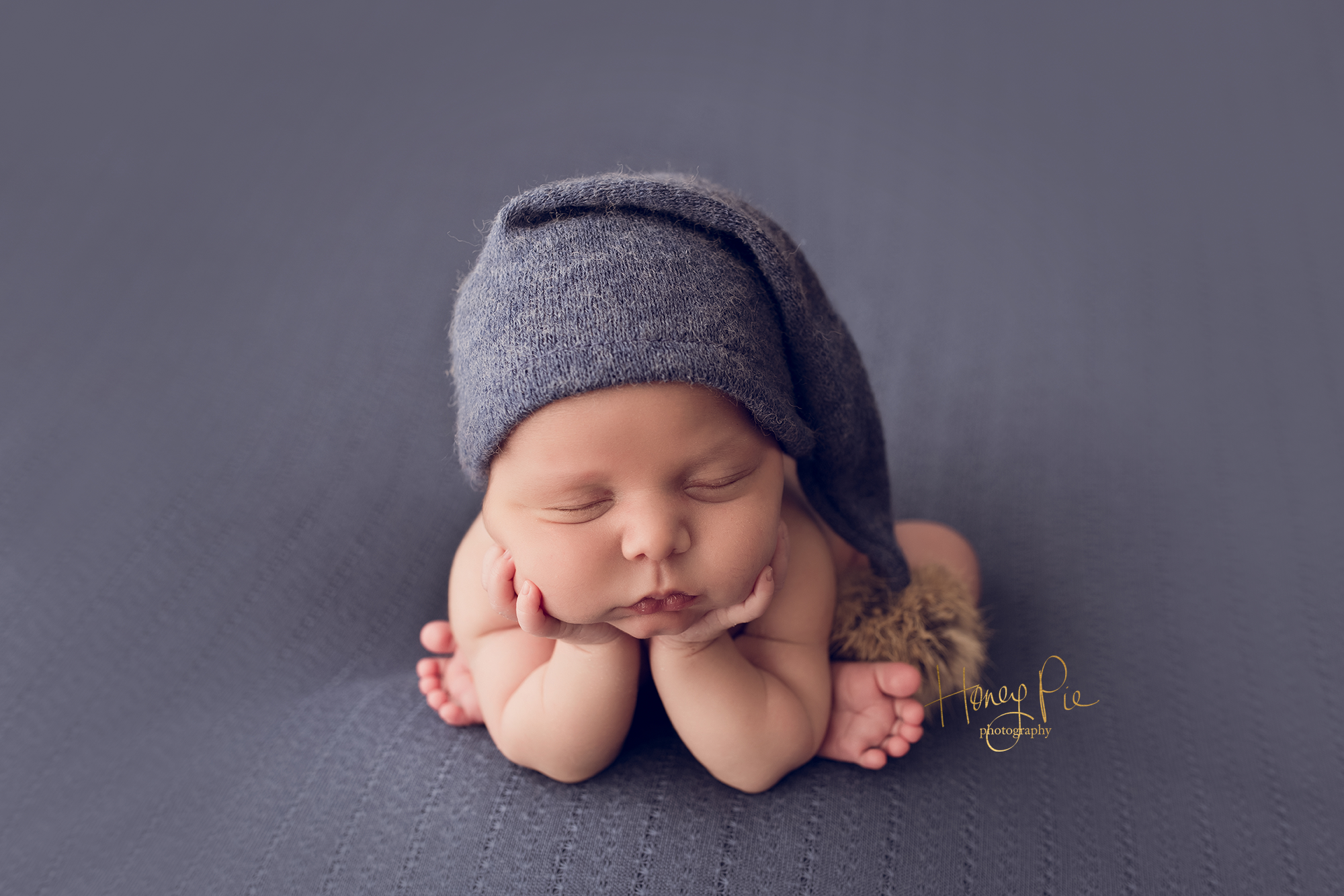 Newborn fast asleep in froggie pose during his newborn photoshoot
