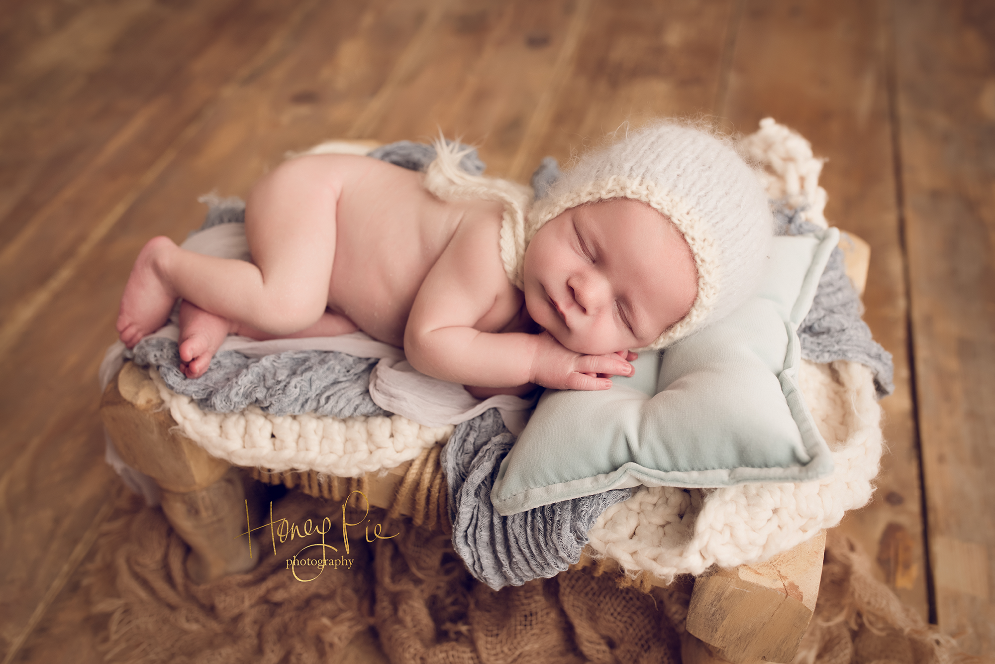 Newborn baby boy fast asleep on a baby blue bed