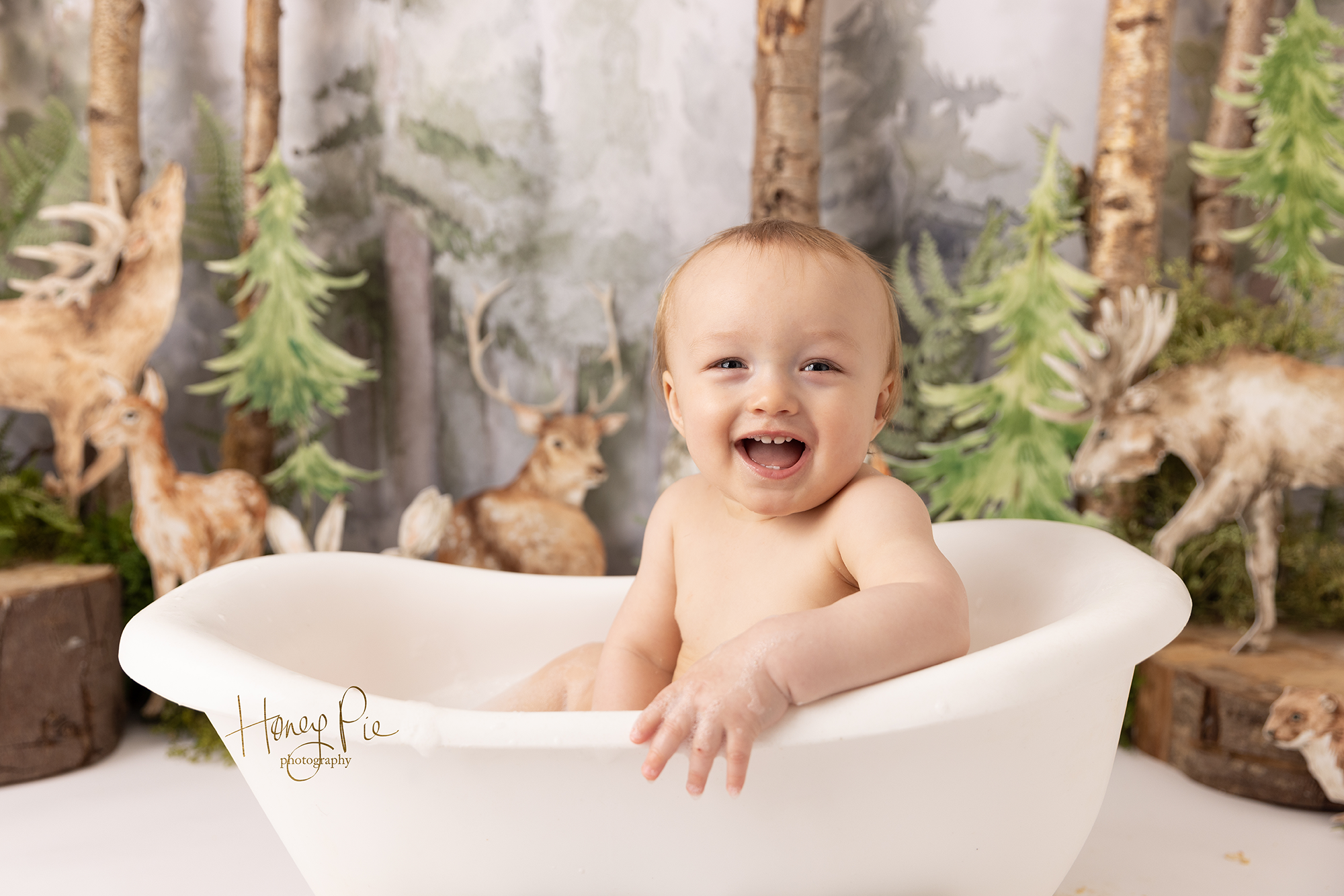 Baby boy in his bubble bath smiling at photographer